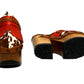 Verona Clogs by Sol Caleyo featuring light brown cow hair leather, red fringe details, and old gold studs on a high wooden platform sole with tractor grip.