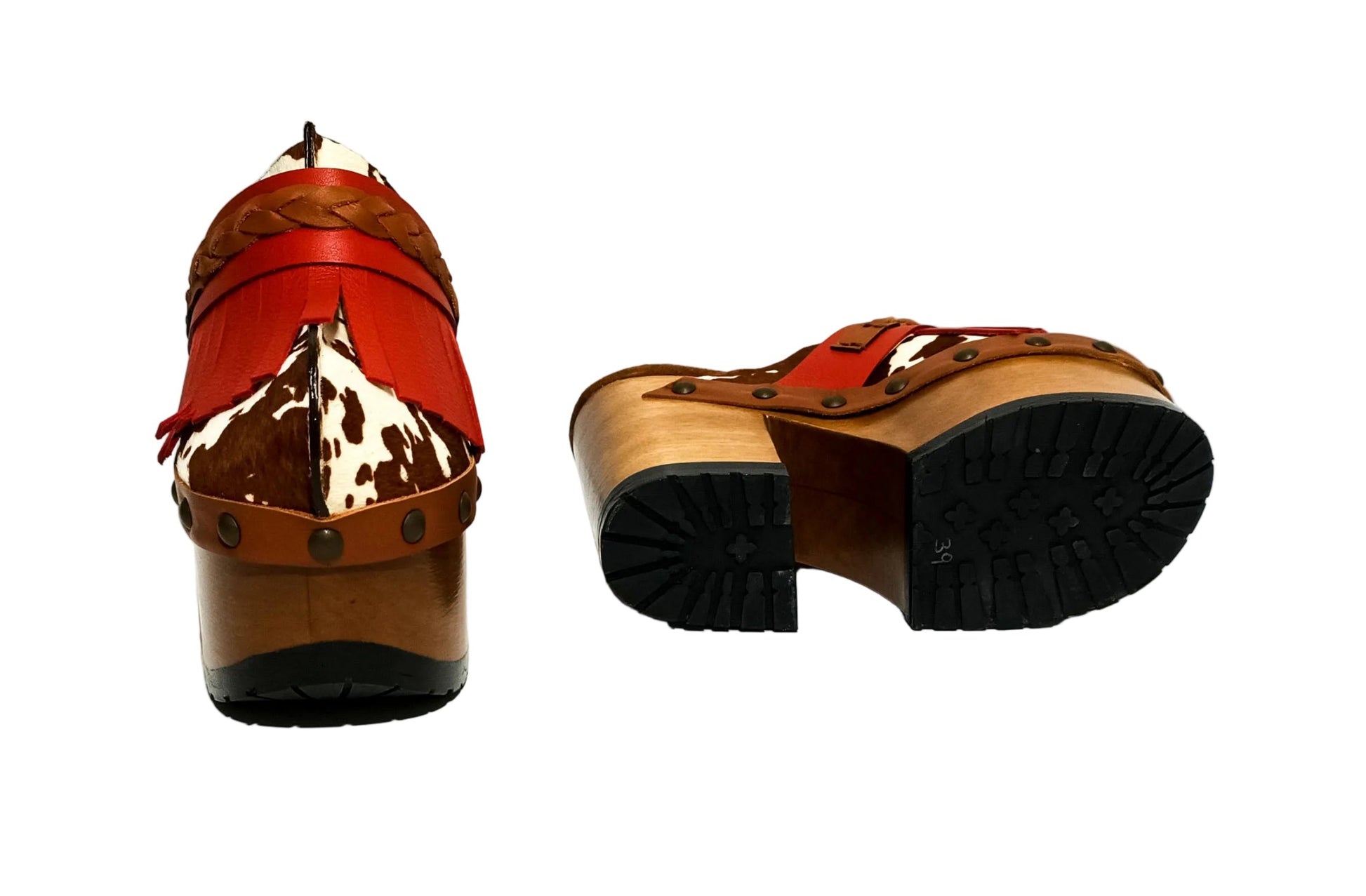 Verona Clogs by Sol Caleyo featuring light brown cow hair leather, red fringe details, and old gold studs on a high wooden platform sole with tractor grip.