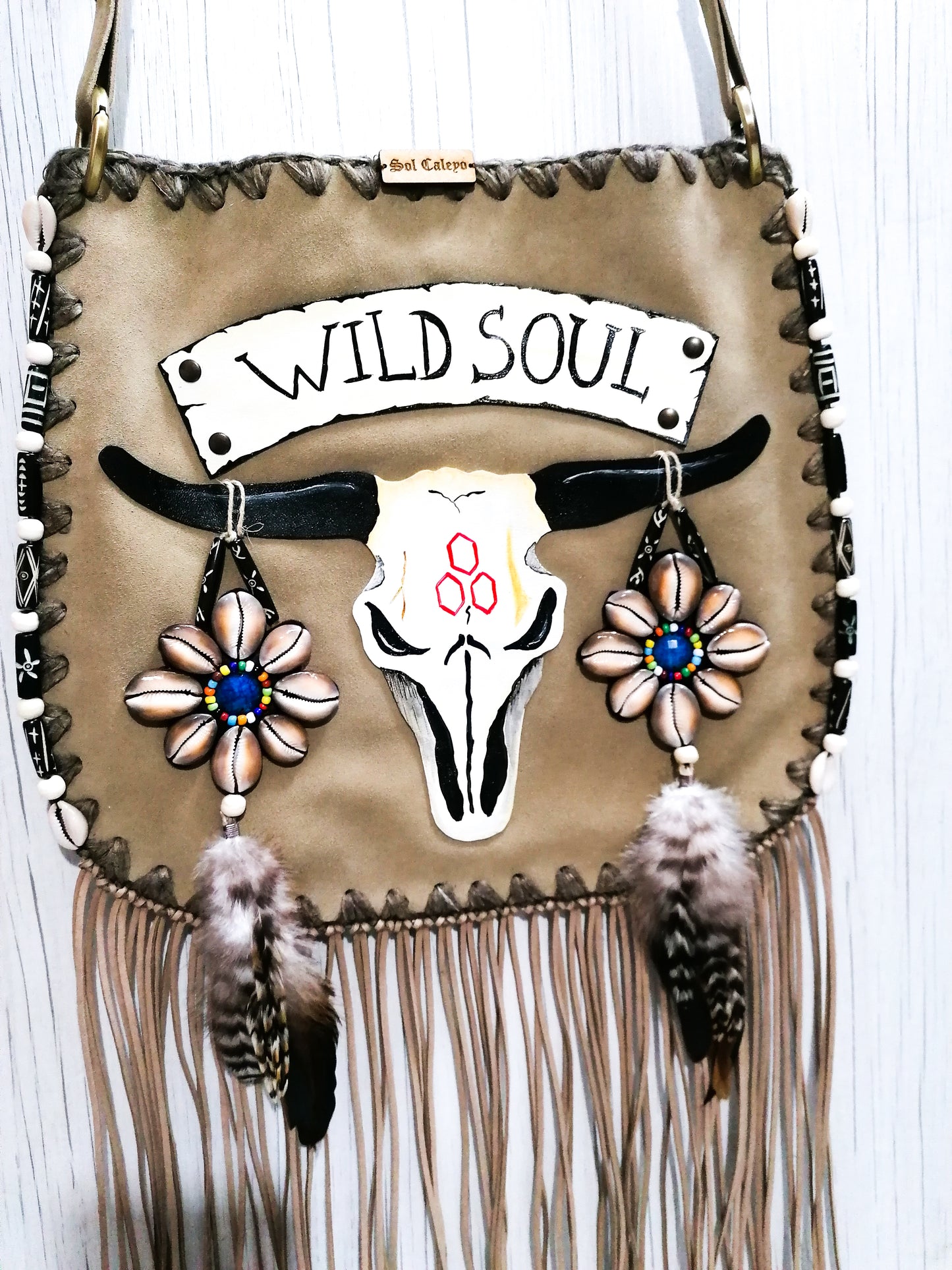 Elevate your bohemian style with this exquisite handmade suede leather bag, featuring a stunning buffalo head design that is hand-painted and intricately embroidered. Every detail is crafted by hand, ensuring a one-of-a-kind piece.