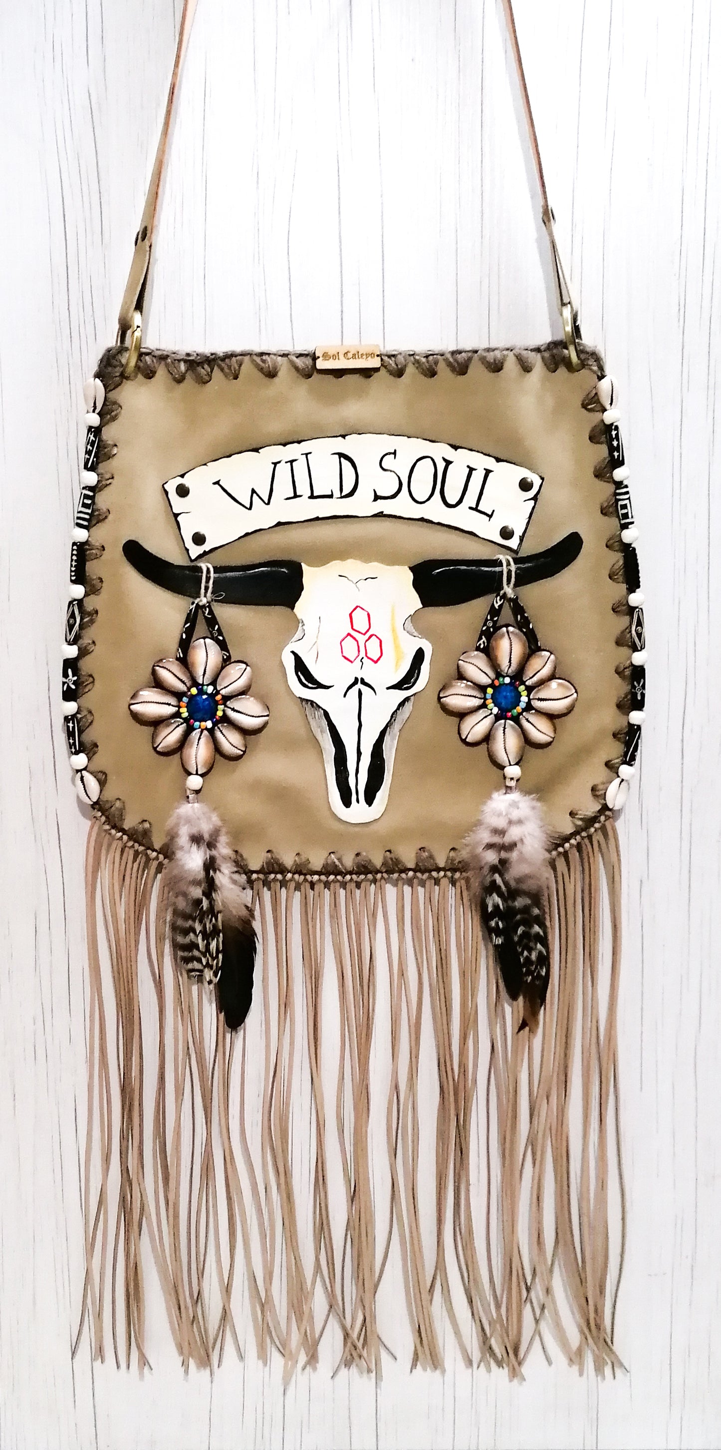 Elevate your bohemian style with this exquisite handmade suede leather bag, featuring a stunning buffalo head design that is hand-painted and intricately embroidered. Every detail is crafted by hand, ensuring a one-of-a-kind piece.