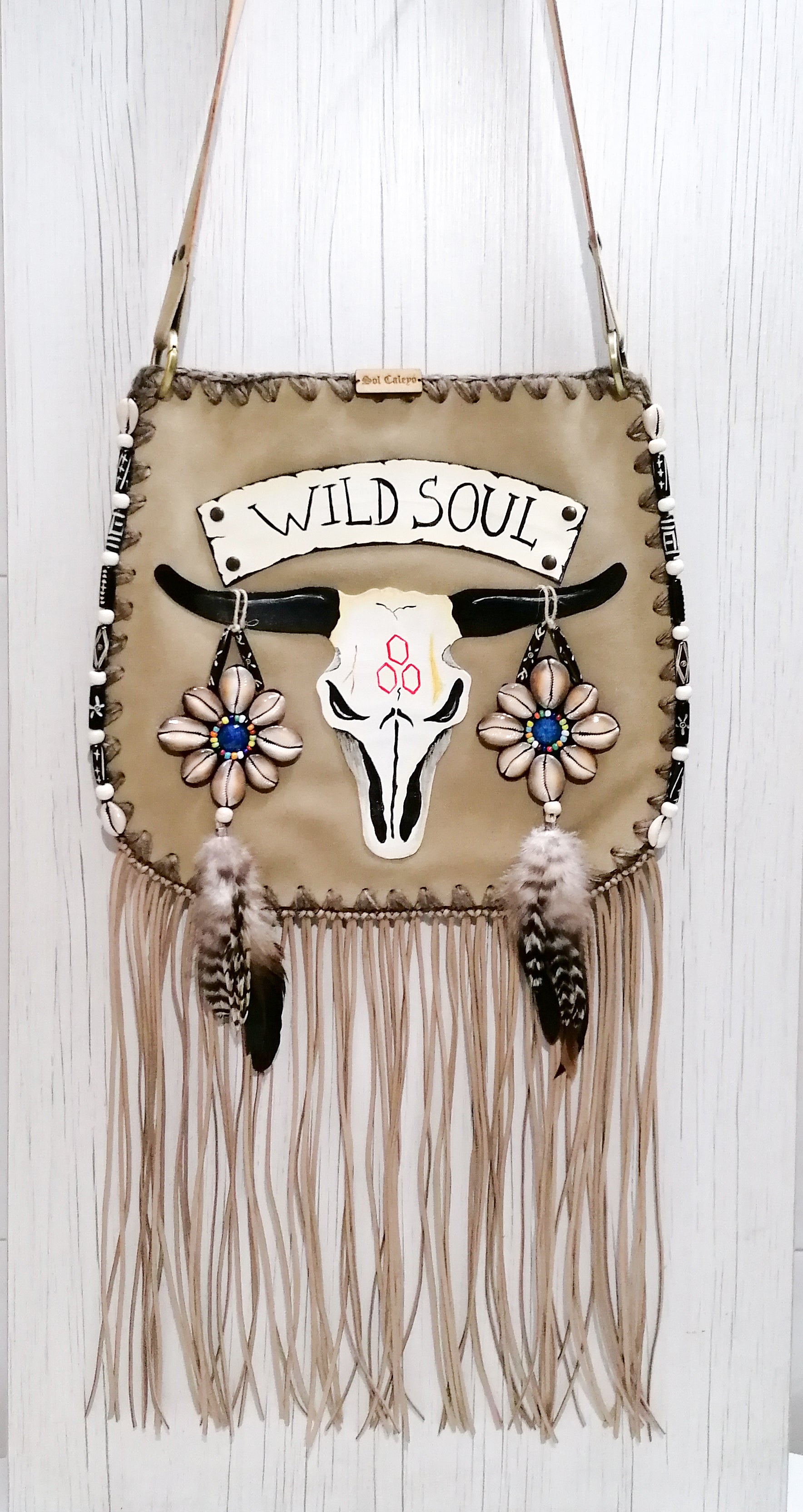 Elevate your bohemian style with this exquisite handmade suede leather bag, featuring a stunning buffalo head design that is hand-painted and intricately embroidered. Every detail is crafted by hand, ensuring a one-of-a-kind piece.