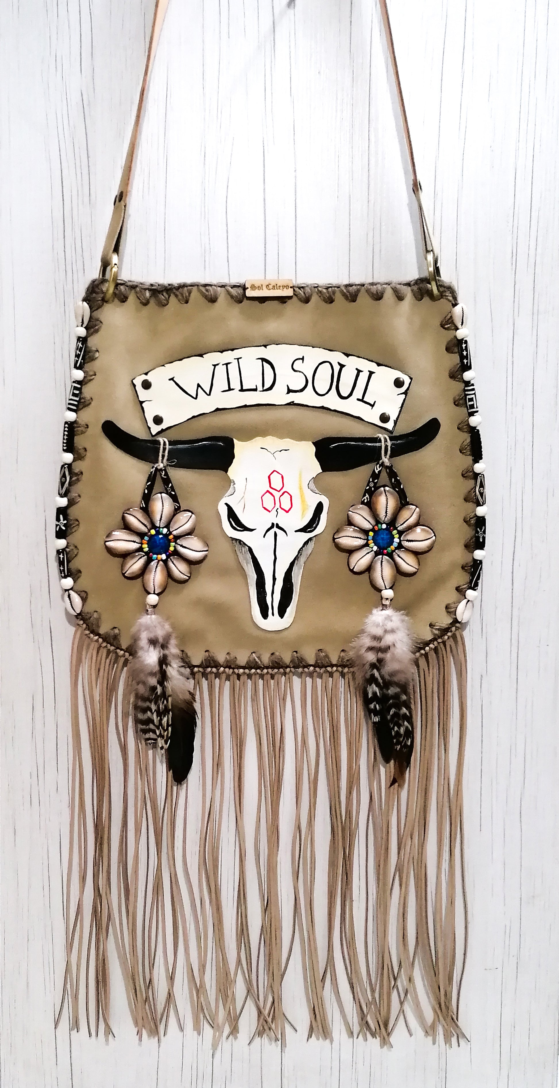 Elevate your bohemian style with this exquisite handmade suede leather bag, featuring a stunning buffalo head design that is hand-painted and intricately embroidered. Every detail is crafted by hand, ensuring a one-of-a-kind piece.