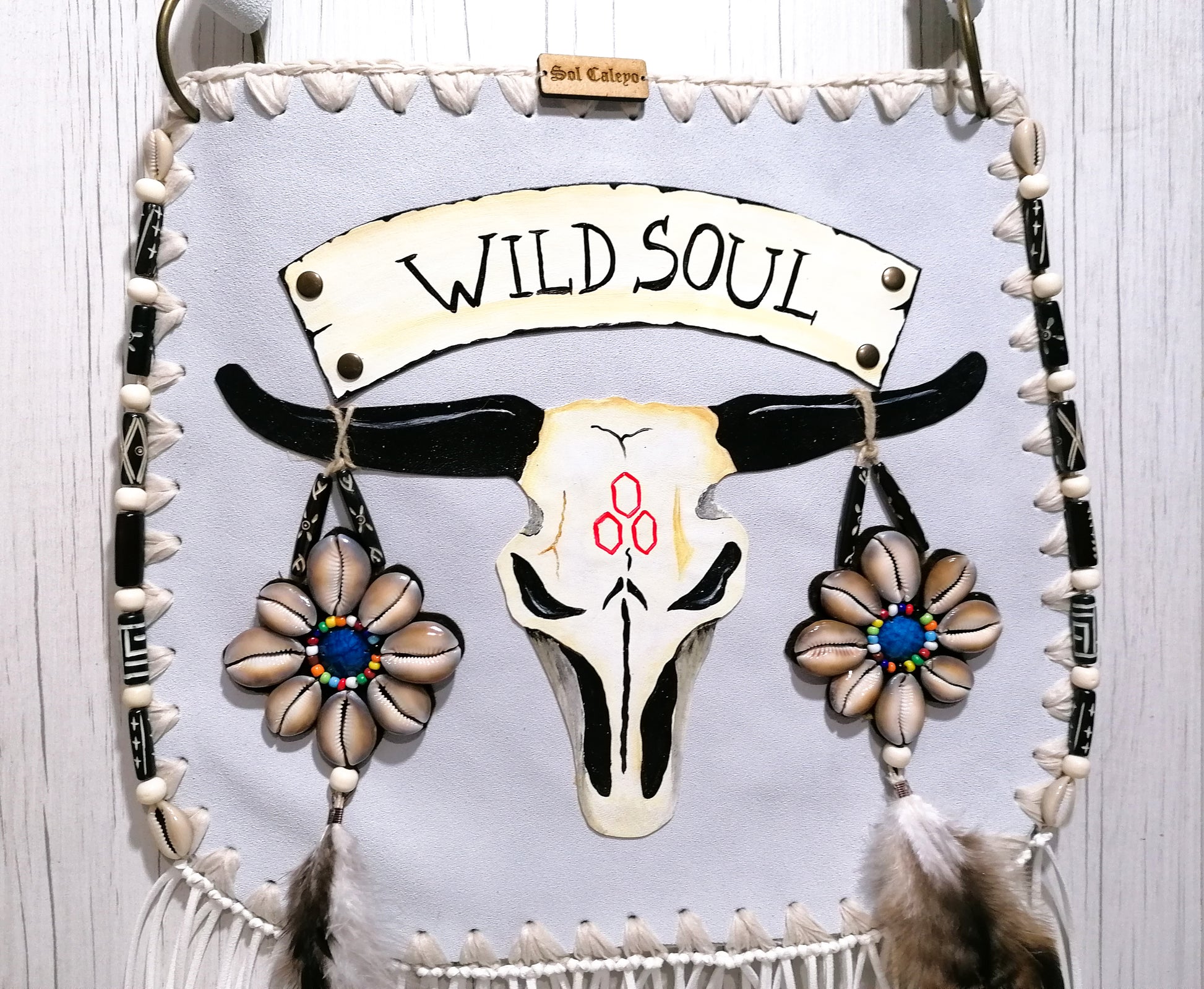 Elevate your bohemian style with this exquisite handmade suede leather bag, featuring a stunning buffalo head design that is hand-painted and intricately embroidered. Every detail is crafted by hand, ensuring a one-of-a-kind piece.