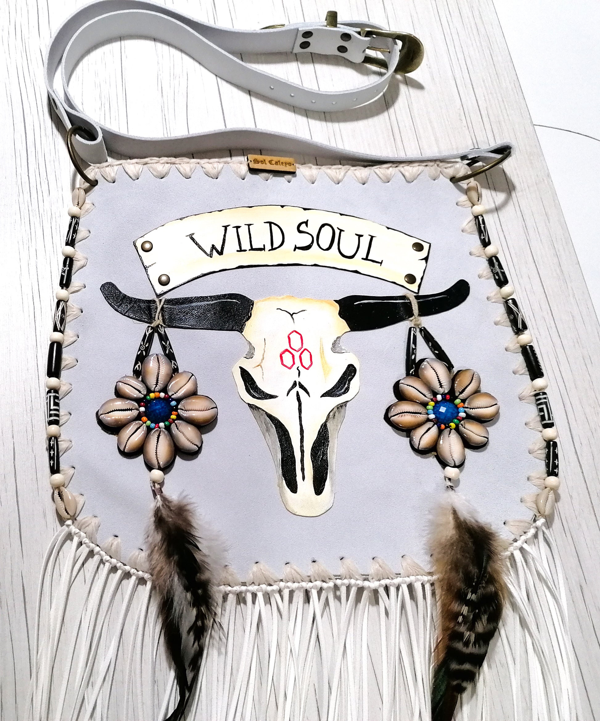 Elevate your bohemian style with this exquisite handmade suede leather bag, featuring a stunning buffalo head design that is hand-painted and intricately embroidered. Every detail is crafted by hand, ensuring a one-of-a-kind piece.