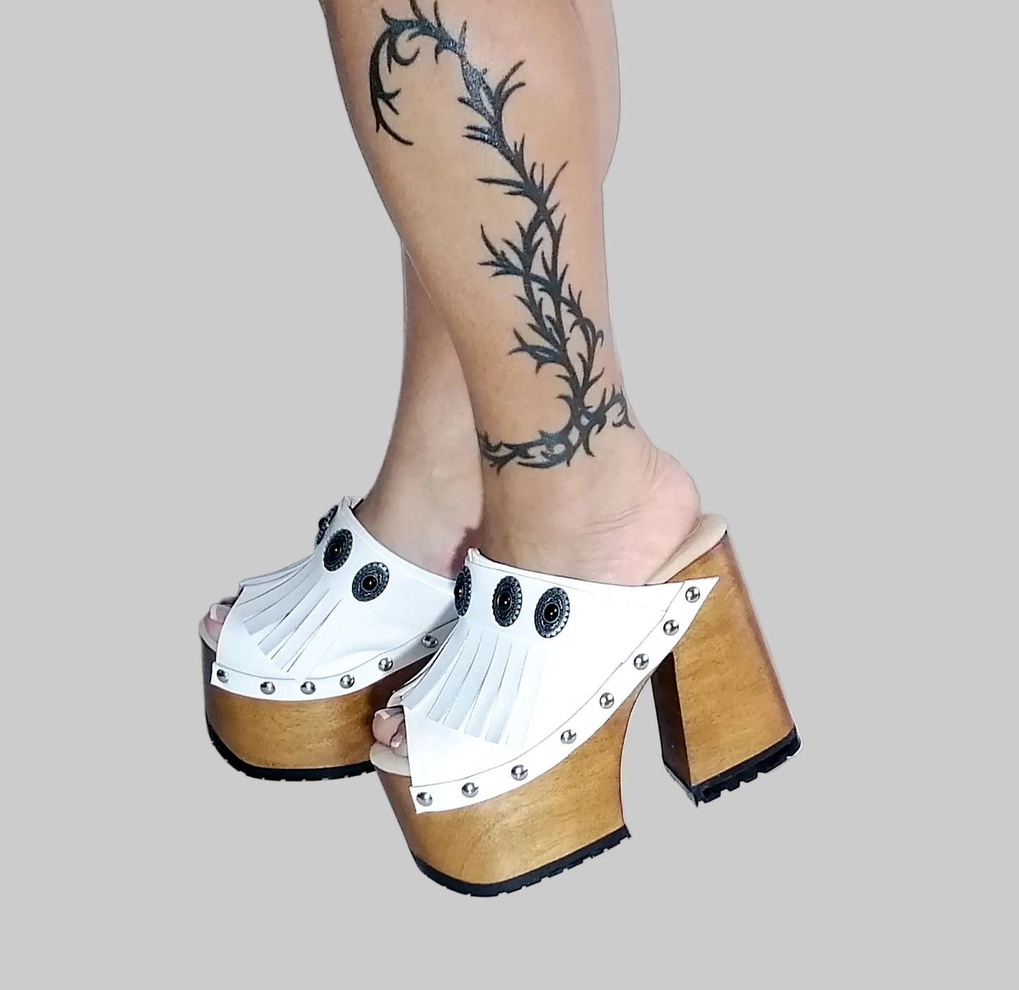White leather sandal. White leather sandal boho style. White leather sandal decorated with fringes and silver conchos with a unique boho style. Wooden clog sandals with super high heels 70's style. Sizes 34 to 47. High quality handmade leather shoes by sol Caleyo. Sustainable fashion.