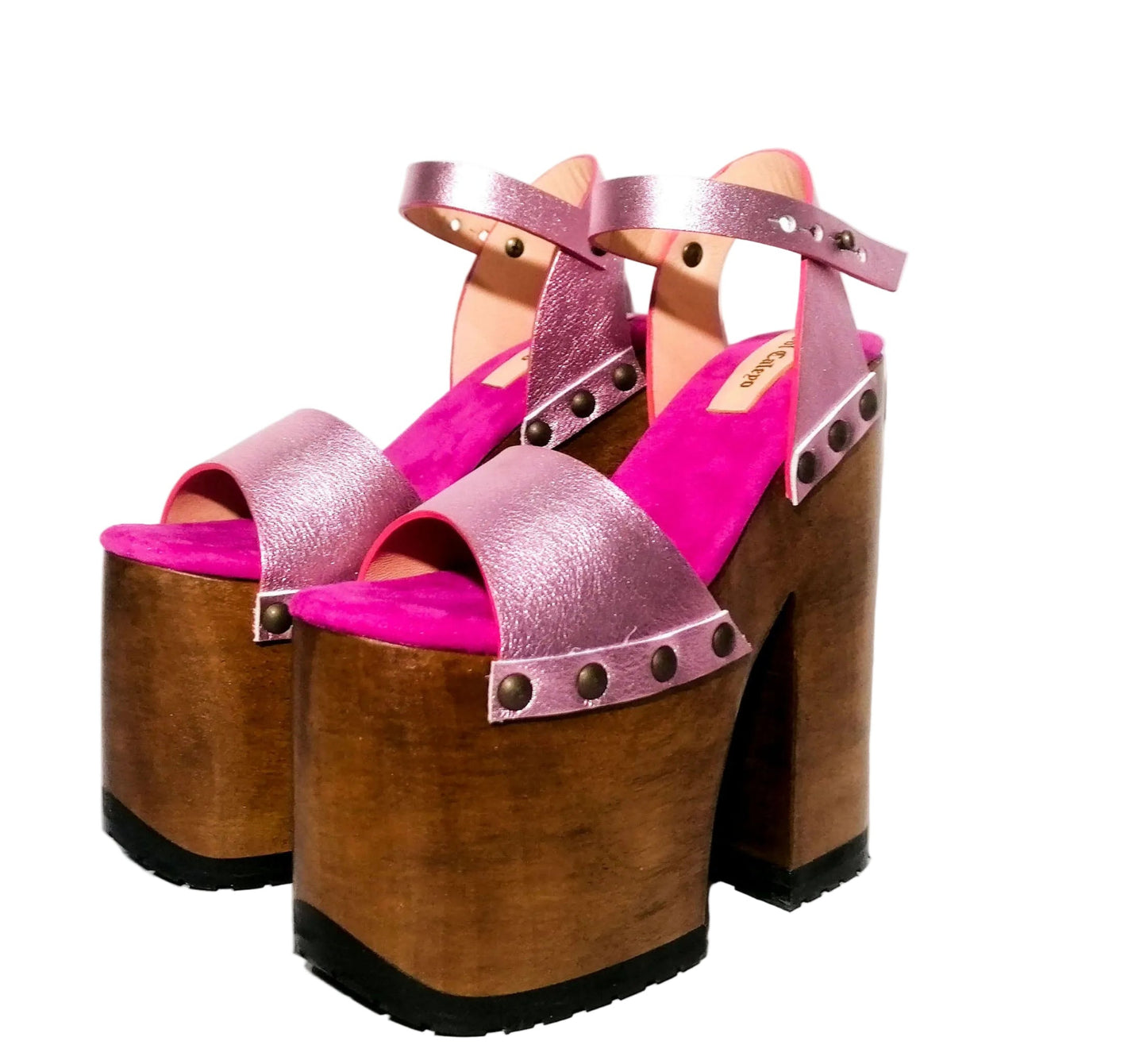 Handmade Crazy Pink metallic leather platform sandals by Sol Caleyo featuring old gold studs, a dark wood platform, and an 17 cm heel on a white background.