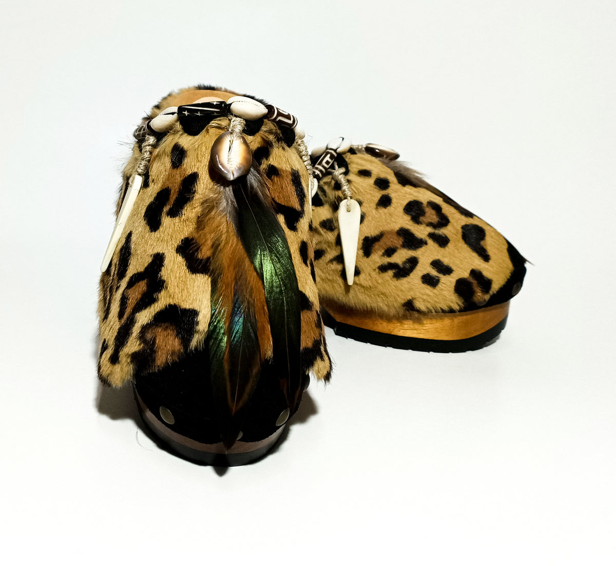 Handmade black suede closed-toe platform mule clogs with leopard print rabbit fur, feathers, horns and 6 cm natural lacquered wooden heel by Sol Caleyo.
