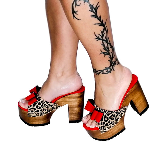 Handmade leopard print suede leather peep toe platform mule sandals with red leather bow, old-gold studs and 12 cm straight light oak lacquered wooden heel by Sol Caleyo.