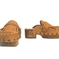 Side profile of Sol Caleyo Niza Clogs in light brown leather, showcasing hand-braided strap, crochet trim, bronze studs, and a sturdy wooden platform sole.