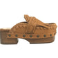 Side profile of Sol Caleyo Niza Clogs in light brown leather, showcasing hand-braided strap, crochet trim, bronze studs, and a sturdy wooden platform sole.