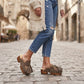 Model wearing Artemisa Earth Tone Suede Tassel Clogs with wooden platform and crochet details outdoors