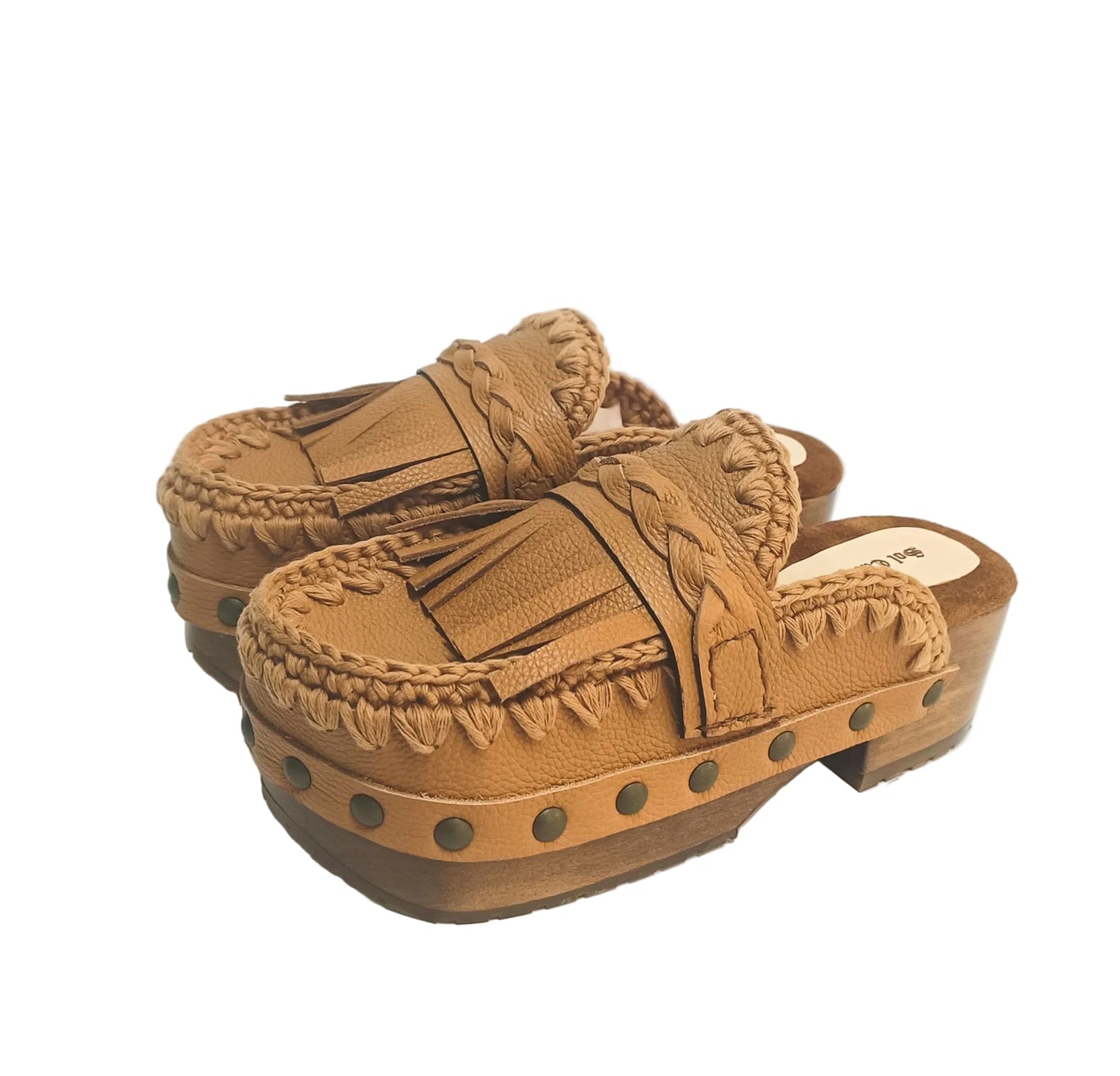 Side profile of Sol Caleyo Niza Clogs in light brown leather, showcasing hand-braided strap, crochet trim, bronze studs, and a sturdy wooden platform sole.
