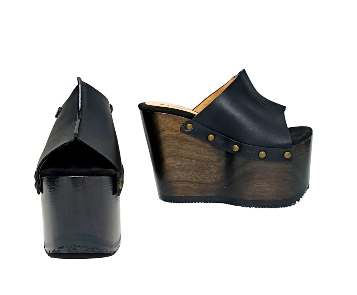 Vintage 70s-style black leather clogs with super high wooden wedge heels. Handmade to order.
Available in sizes 34 to 47.
An exclusive design by Sol Caleyo, created for those who value craftsmanship, comfort, and authentic style.