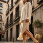Sol Caleyo Niza Moccasin Clogs in light brown leather worn on a cobblestone street, featuring crochet details, fringes, and a wooden platform sole