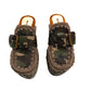 Handcrafted military camouflage and brown leather platform clog with unique crochet stitch edging and antique gold buckle detailing on a sturdy wooden base with a rugged black rubber outsole.