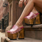 Pink metallic handmade leather mule clogs with bronze-tone studs and 17 cm bell-style wooden heel by Sol Caleyo.