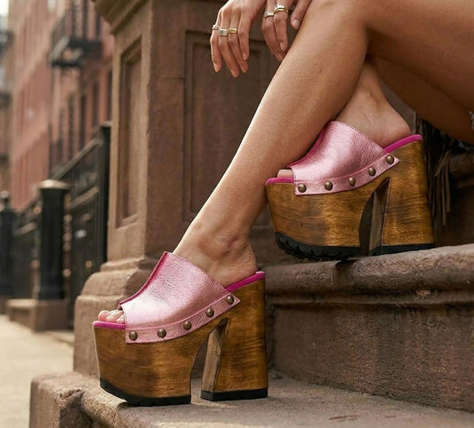 Pink metallic handmade leather mule clogs with bronze-tone studs and 17 cm bell-style wooden heel by Sol Caleyo.