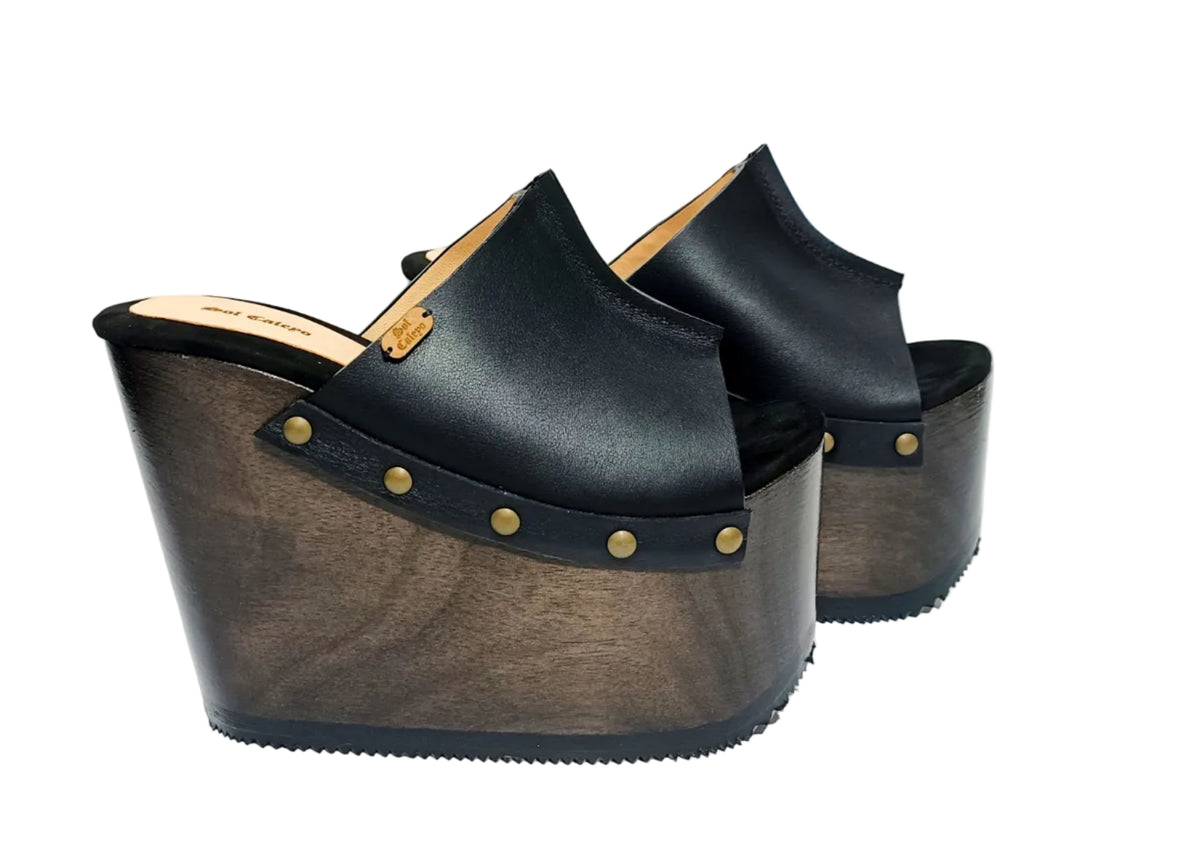 Vintage 70s-style black leather clogs with super high wooden wedge heels. Handmade to order.
Available in sizes 34 to 47.
An exclusive design by Sol Caleyo, created for those who value craftsmanship, comfort, and authentic style.