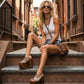 Handmade snake print leather mule sandals with studs and 17 cm bell-style hand-carved wooden heel by Sol Caleyo.