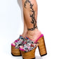 Handmade pink tattoo print leather open toe platform mule sandals with wide strap, old-gold studs and 17 cm natural lacquered straight wooden heel by Sol Caleyo.