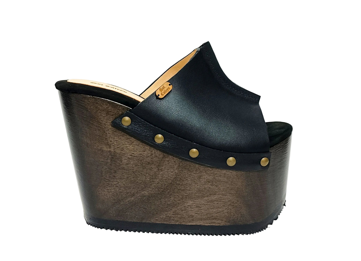 Vintage 70s-style black leather clogs with super high wooden wedge heels. Handmade to order.
Available in sizes 34 to 47.
An exclusive design by Sol Caleyo, created for those who value craftsmanship, comfort, and authentic style.