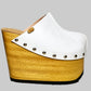 Handmade white leather open-back wedge mule clogs with silver studs and 15 cm light wooden wedge by Sol Caleyo.