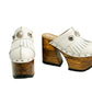 Side view of White Indian Clogs XL featuring extreme 17cm natural wood platform, white leather fringes, and antique silver metal conchos.
