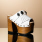 White handmade leather boho platform mule sandals with fringe, silver conchos and 14 cm wooden heel by Sol Caleyo