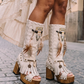Wild Soul white suede boho boots by Sol Caleyo, handmade with hand painted buffalo, shells and feathers on a 12 cm wooden heel