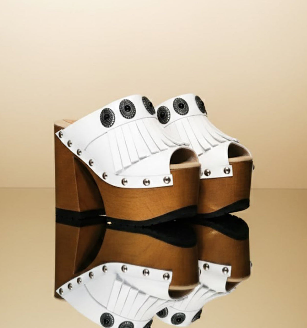 White handmade leather boho platform mule sandals with fringe, silver conchos and 14 cm wooden heel by Sol Caleyo