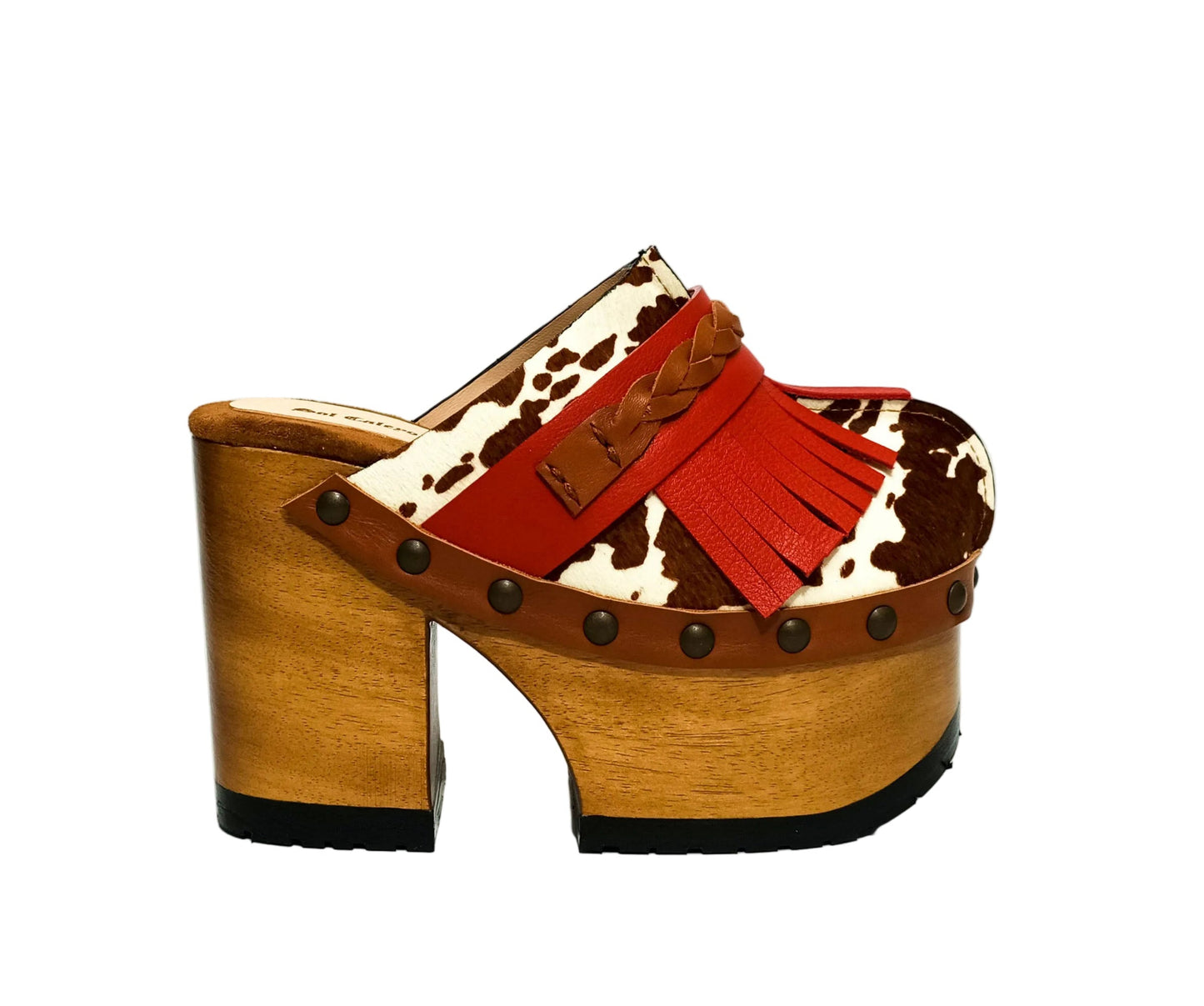 Verona Clogs by Sol Caleyo featuring light brown cow hair leather, red fringe details, and old gold studs on a high wooden platform sole with tractor grip.