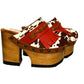 Verona Clogs by Sol Caleyo featuring light brown cow hair leather, red fringe details, and old gold studs on a high wooden platform sole with tractor grip.
