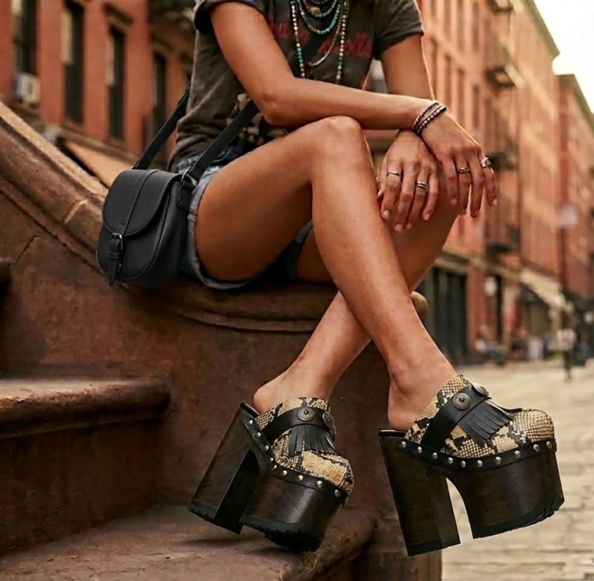 Blogger wearing Indian Snake Clogs with a white tank top and denim shorts, showcasing the 18cm platform height in an urban setting.