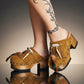 Bohemian style clogs, natural shell accessories, leather clogs decorated with feathers and natural shells. Boho style leather clogs. High-end handmade footwear by Sol Caleyo.