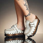 White wooden wedge clogs. White leather mules. Oxford style buckle clogs. High quality handmade shoes by Sol Caleyo.