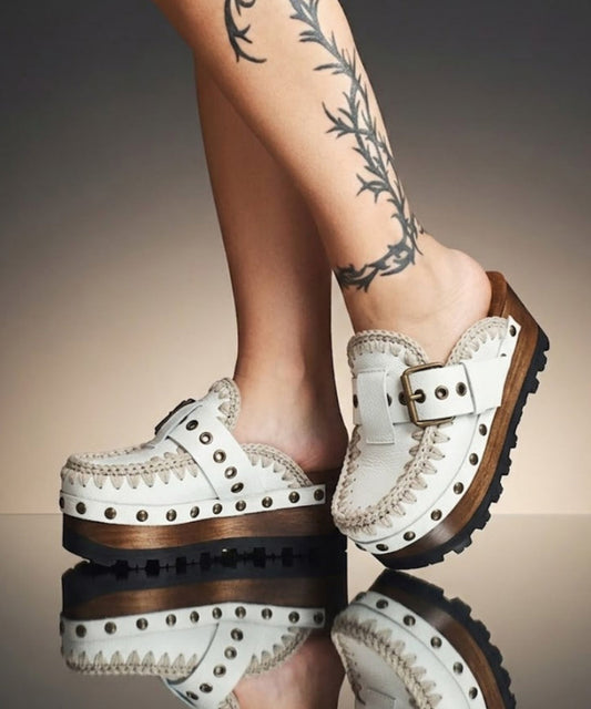 White wooden wedge clogs. White leather mules. Oxford style buckle clogs. High quality handmade shoes by Sol Caleyo.