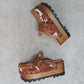 Oxford Clogs Cowhide Print by Sol Caleyo: handmade wooden platform clogs with cowhide hair-on leather, crochet trim, and aged camel leather strap.