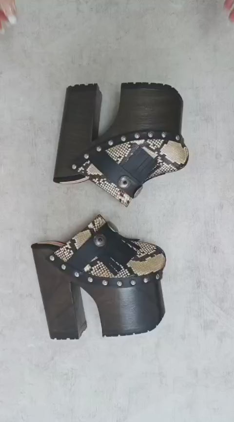 Indian Snake Clogs by Sol Caleyo: extreme 18cm straight heel wooden platforms with snake-print leather, black fringe, and Native American style metal conchos.