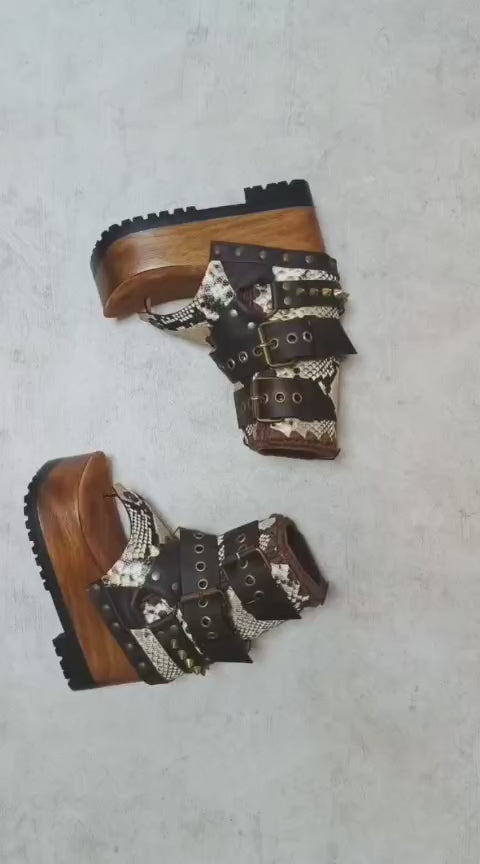 Sol Caleyo Kenya Flip Flop Snake Boots: handmade python print leather platform sandals with brown buckled straps and wooden tractor sole.