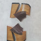 Side view of Sol Caleyo Brown Luxury Queen Sandals featuring deep brown leather, bronze studs, and a high architectural wooden platform heel against a white background.