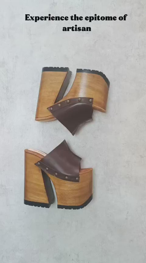 Side view of Sol Caleyo Brown Luxury Queen Sandals featuring deep brown leather, bronze studs, and a high architectural wooden platform heel against a white background.
