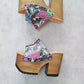 Video of the handmade Las Vegas pop print leather platform mule sandals with a wide strap, old-gold studs and a 13 cm natural wooden heel, by Sol Caleyo