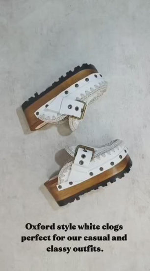White wooden wedge clogs. White leather mules. Oxford style buckle clogs. High quality handmade shoes by Sol Caleyo.