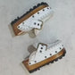 White wooden wedge clogs. White leather mules. Oxford style buckle clogs. High quality handmade shoes by Sol Caleyo.