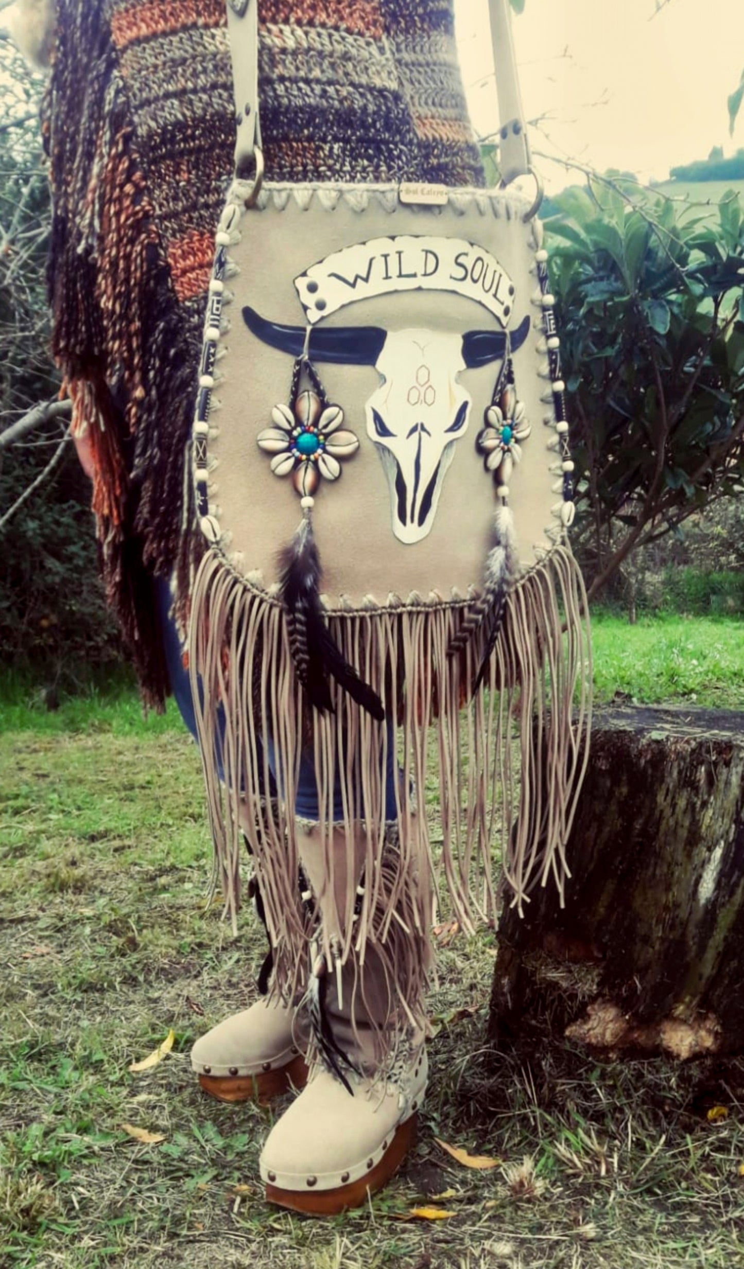 Elevate your bohemian style with this exquisite handmade suede leather bag, featuring a stunning buffalo head design that is hand-painted and intricately embroidered. Every detail is crafted by hand, ensuring a one-of-a-kind piece.