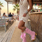 A model wearing the Rhapsody Bohemia Pink Boots at a rustic beach bar. The vibrant pink suede and bohemian details stand out against the sun-drenched wooden deck and coastal decor, embodying a free-spirited summer style.