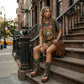 Model wearing Alabama Flip Flops Army Boots with camouflage print leather, styled in a rugged military-chic look with 10 cm platform wedges and gold studs.