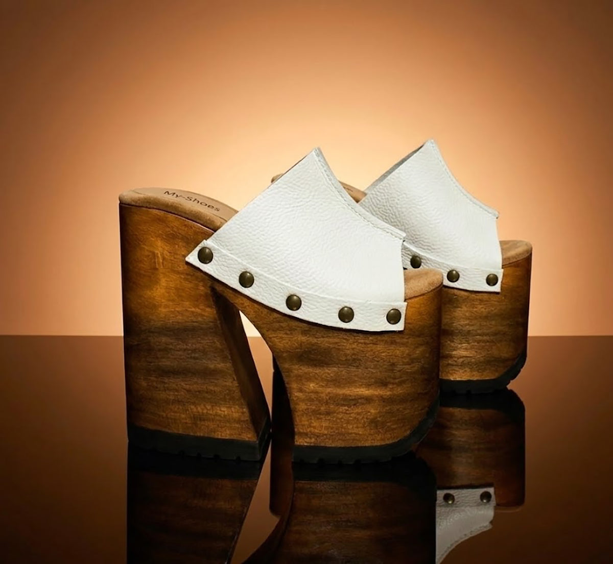 Side view of White Luxury Queen Sandals by Sol Caleyo featuring 17cm bell-style wooden heel and 11cm hand-carved platform. High-end handcrafted white leather platform sandals with vintage studs and padded goatskin suede insole. Artisanal luxury footwear for women, 100% handmade.