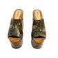 Handcrafted Armi Luxury Queen Sandals by Sol Caleyo featuring camouflage print leather, 17cm bell heel, and 11cm hand-carved wooden platform on a white background.