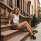 Fashion model wearing Armi Luxury Queen camouflage leather platform sandals with high wooden heels and vintage studs, showcasing a bold military-chic summer look.